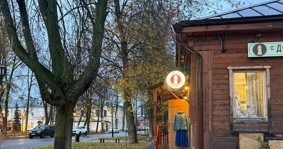 Une rue de Souzdal un matin d’automne, lampadaires allumés, pavés mouillés et une boutique en bois avec un costume traditionnel dans l’entrée