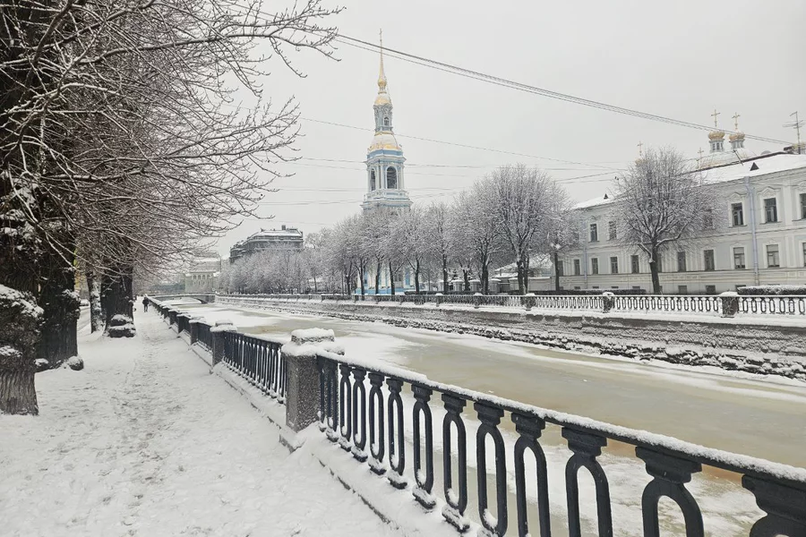 Un canal de Saint-Pétersbourg pris par la glace, le quai enneigé et le clocher de la cathédrale Saint-Nicolas-des-Marins