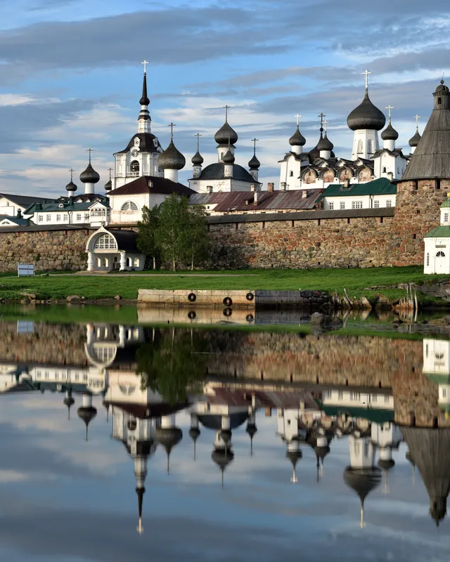 Le monastère des Solovki, ses coupoles et ses remparts de pierre reflétés dans le lac