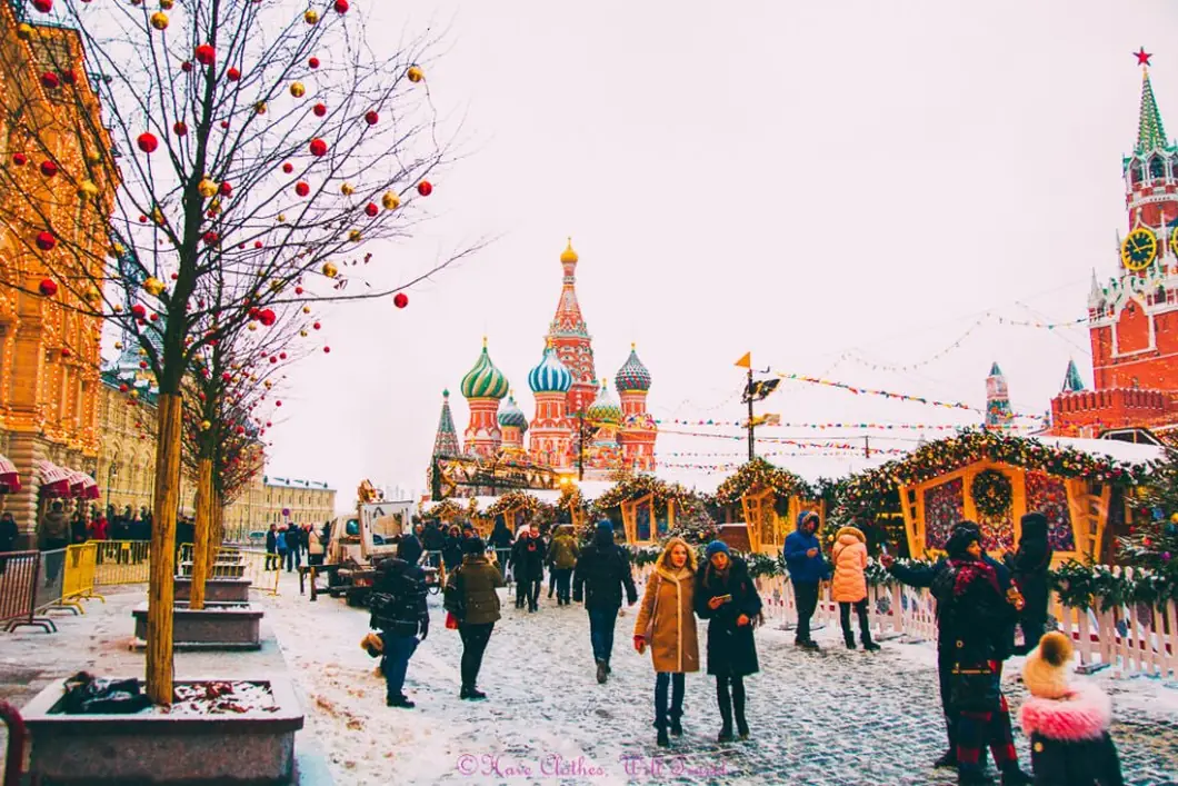 La place Rouge en foire de Noël sous la neige, Saint-Basile et la tour Spasskaïa en fond